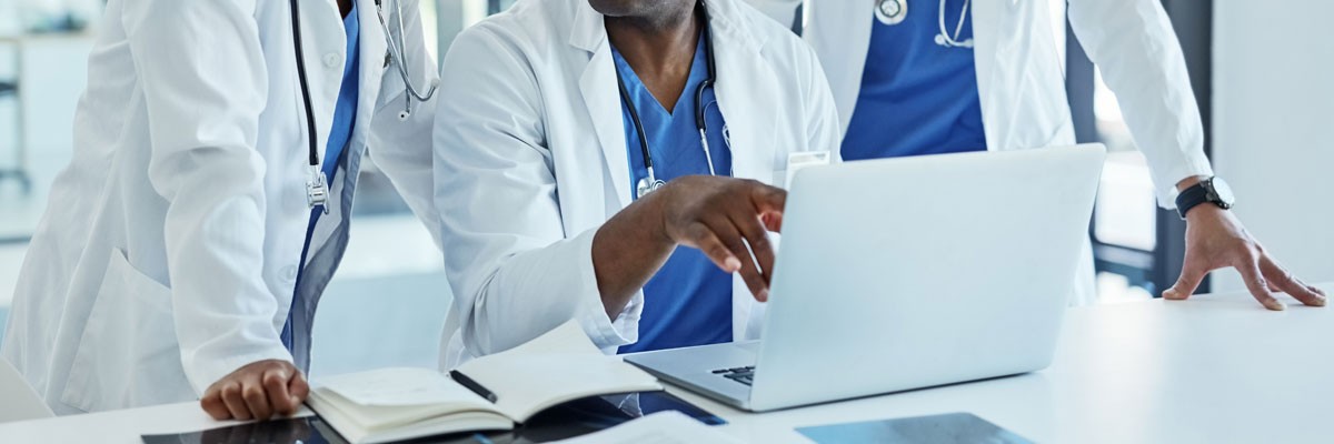 Healthcare professionals gathered around laptop
