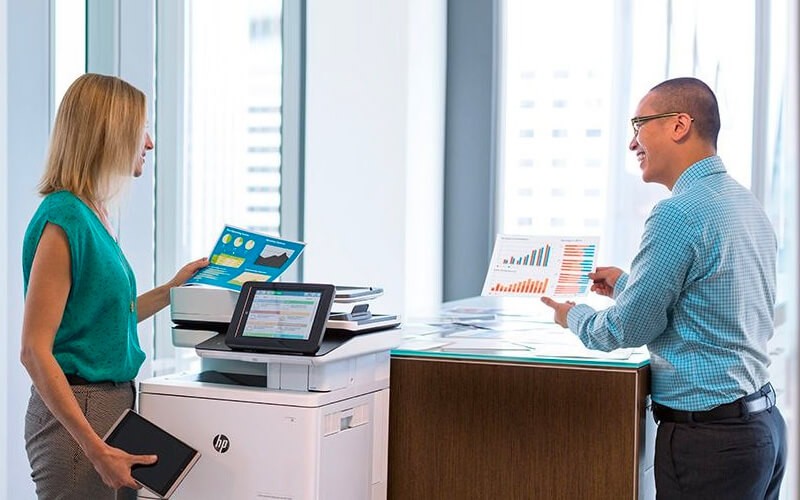 Two colleagues talking to each other while using HP printer